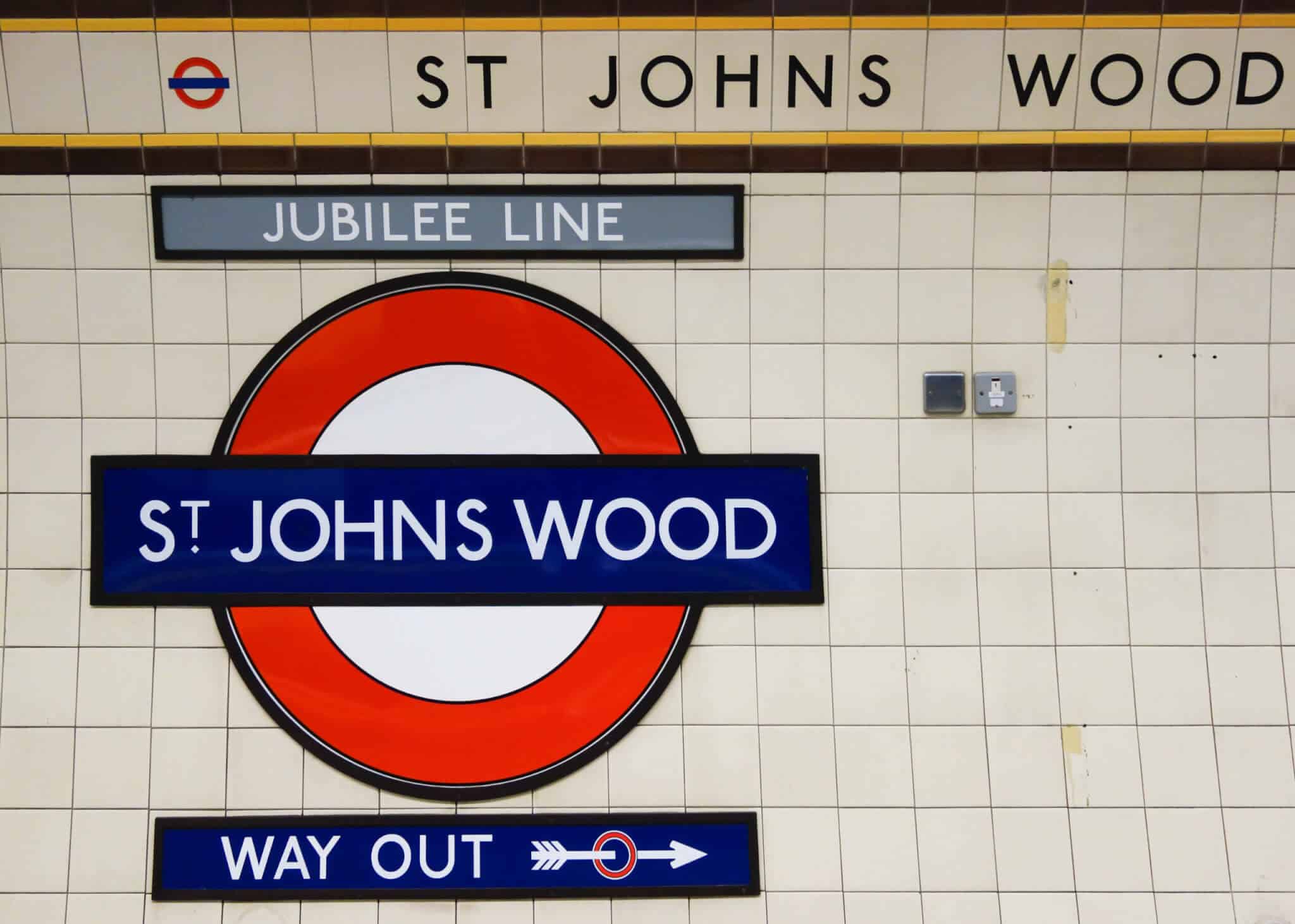 St Johns Wood London underground station sign with Jubilee Line and Way Out indicators, set against a tiled wall.