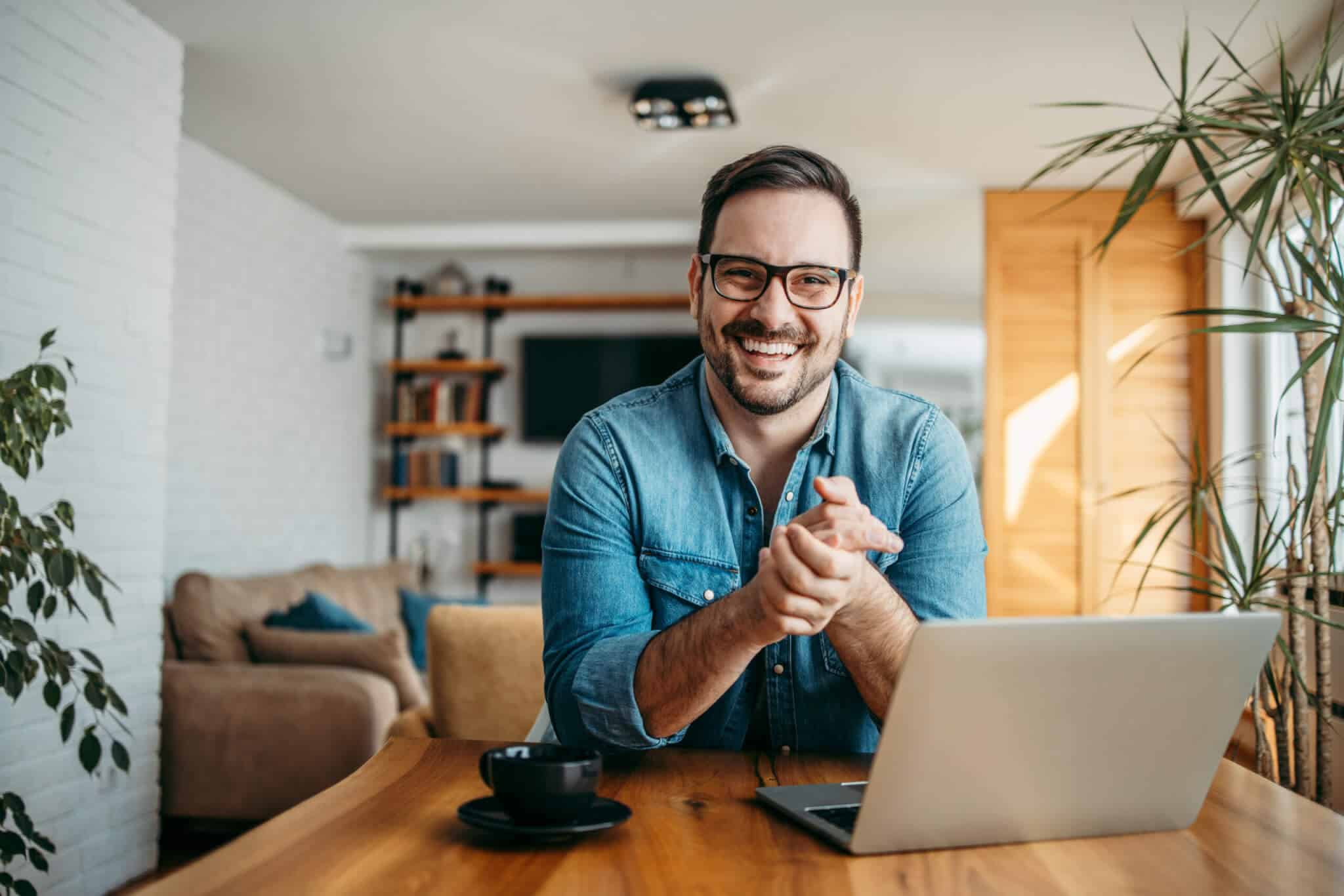 Man with Glasses Smiling at Laptop